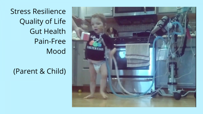 Toddler in residential kitchen connected to portable medical equipment