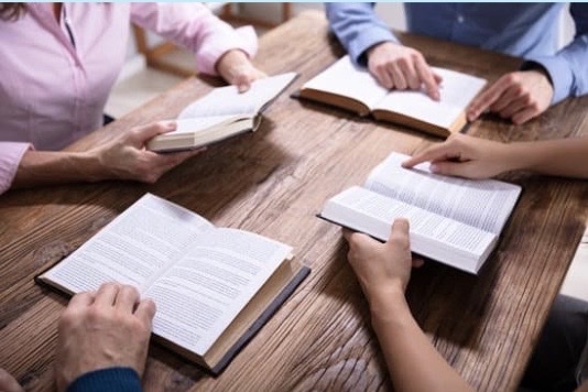 Women seated at a table, with their bibles open.
